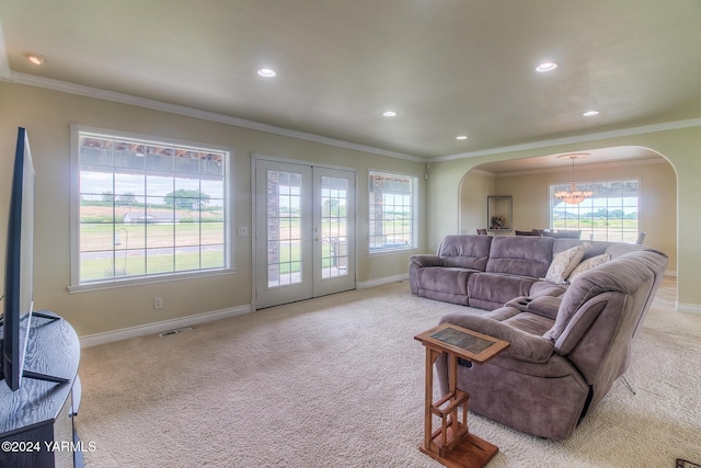 living area with light colored carpet, arched walkways, visible vents, and baseboards