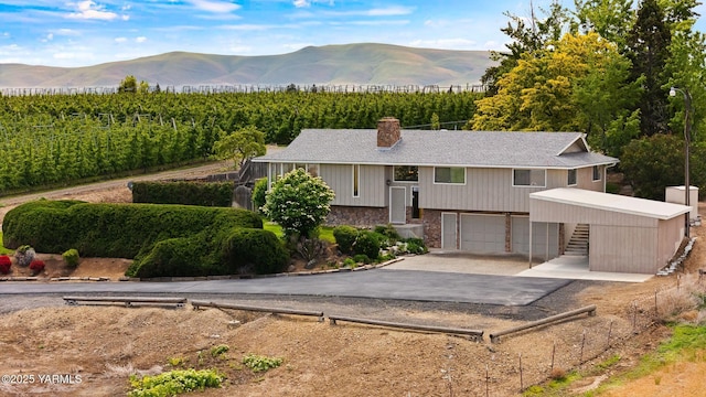 10800 Zier Rd, Yakima, WA 98908 - raised ranch featuring asphalt driveway, a chimney, stone siding, agricultural area, and an attached garage