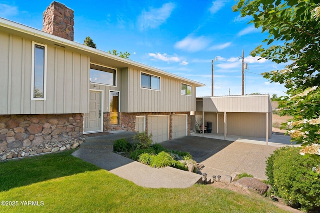 10800 Zier Rd, Yakima, WA 98908 - view of front facade featuring a garage, a chimney, a front yard, board and batten siding, and stone siding
