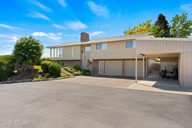 10800 Zier Rd, Yakima, WA 98908 - raised ranch with a chimney, driveway, stone siding, a garage, and stairs