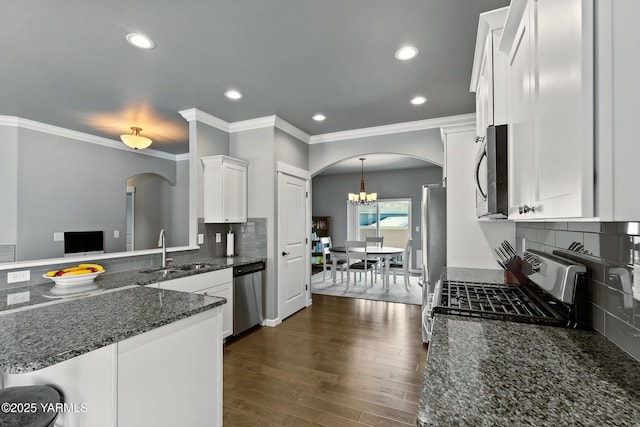7402 Viewcrest Way, Yakima, WA 98908 - kitchen featuring arched walkways, appliances with stainless steel finishes, ornamental molding, white cabinets, and dark stone counters