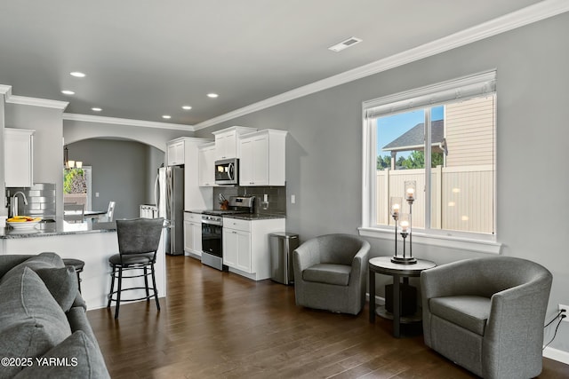 7402 Viewcrest Way, Yakima, WA 98908 - living area with arched walkways, dark wood-style floors, ornamental molding, and recessed lighting