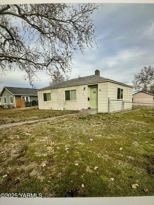 view of front of home featuring a chimney, a front yard, and fence