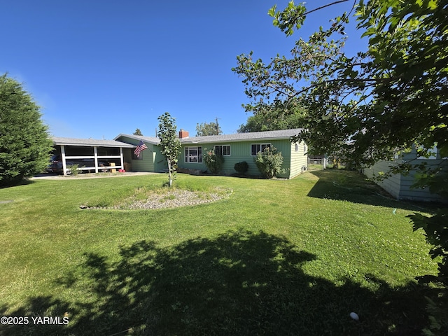 3204 W Viola Ave, Yakima, WA 98902 - back of house featuring a sunroom, a yard, and a chimney