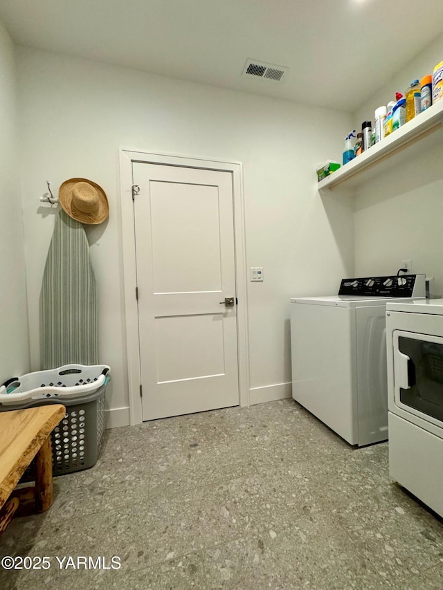 laundry area with laundry area, baseboards, visible vents, and washer and clothes dryer