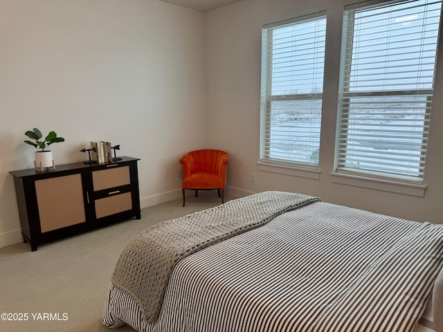 bedroom with light colored carpet and baseboards