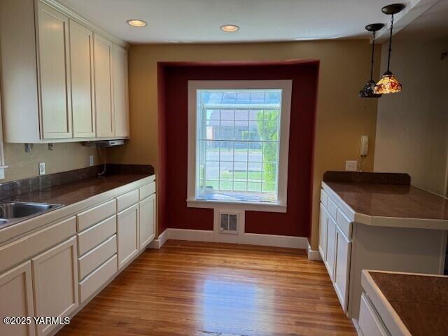 9 W Court St, Union Gap, WA 98903 - kitchen featuring dark countertops, light wood-style floors, decorative light fixtures, white cabinets, and recessed lighting