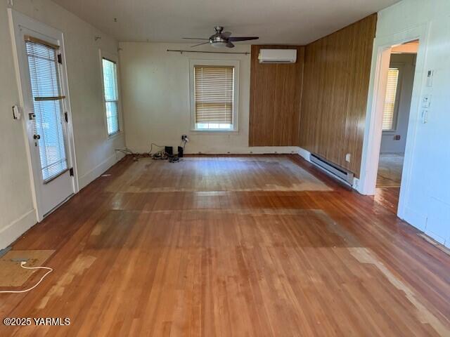 9 W Court St, Union Gap, WA 98903 - unfurnished room with a wall mounted air conditioner, baseboard heating, and wood finished floors