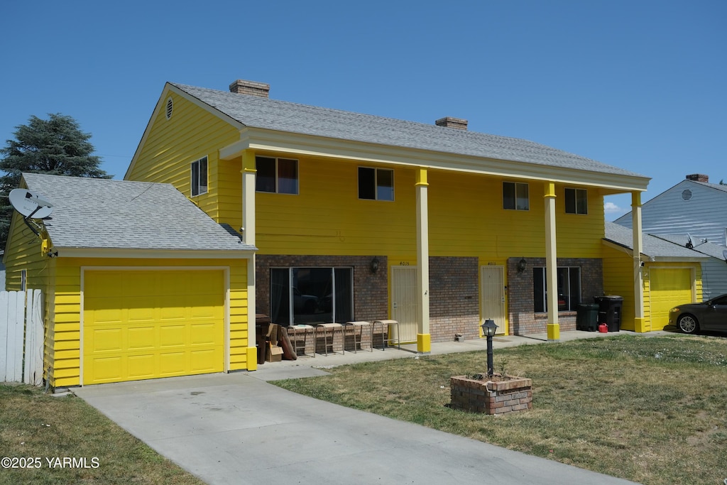 4013/4015 W Walnut St, Yakima, WA 98908 - view of front of home featuring an attached garage, brick siding, a chimney, and driveway