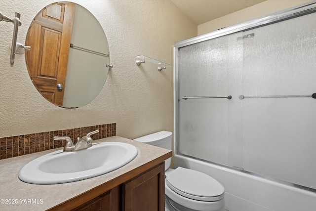 full bath with enclosed tub / shower combo, a textured wall, toilet, vanity, and tasteful backsplash