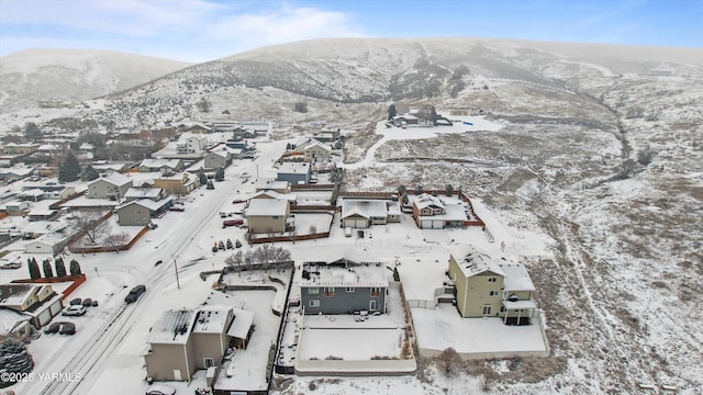 snowy aerial view with a residential view and a mountain view
