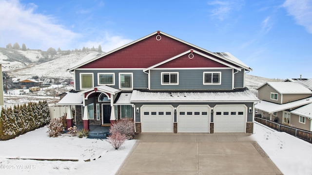 view of front of property featuring concrete driveway, fence, an attached garage, and a mountain view