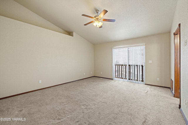 spare room featuring light carpet, baseboards, lofted ceiling, ceiling fan, and a textured ceiling