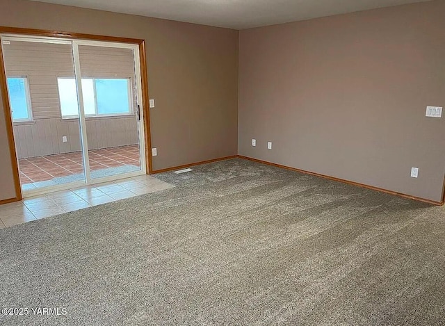 tiled empty room with carpet floors, baseboards, and visible vents