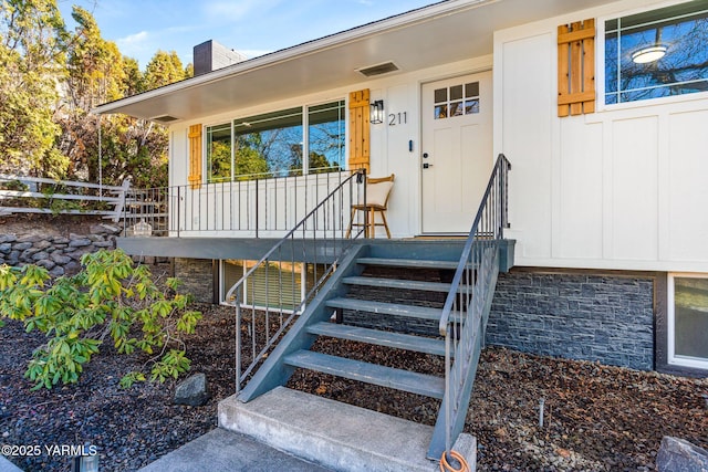 211 N 65th Pl, Yakima, WA 98908 - property entrance featuring a chimney, a porch, board and batten siding, and stone siding