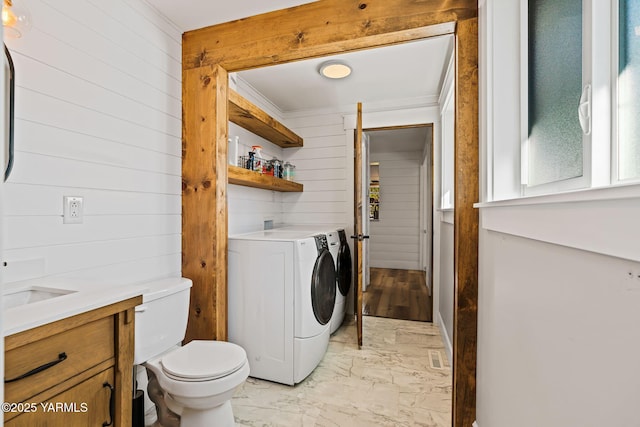 211 N 65th Pl, Yakima, WA 98908 - washroom with wooden walls, washer and clothes dryer, light marble finish flooring, and crown molding