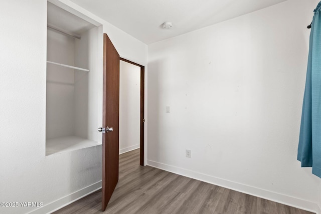 unfurnished bedroom featuring baseboards and wood finished floors