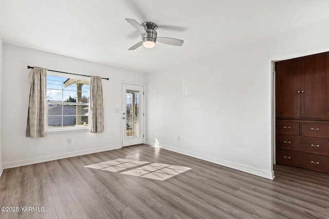 spare room with dark wood finished floors and baseboards