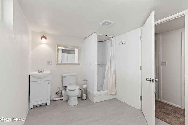 bathroom with visible vents, toilet, a shower stall, vanity, and baseboards