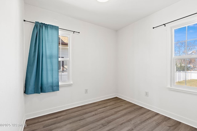 empty room with baseboards and wood finished floors