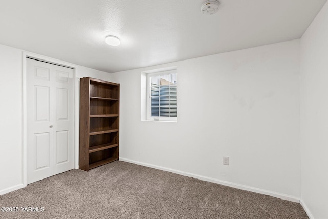 unfurnished bedroom featuring a closet, baseboards, and carpet flooring