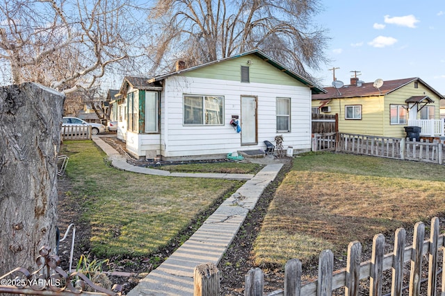 bungalow with fence private yard, a front lawn, and entry steps