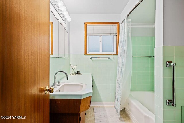 full bath with shower / bath combo, tile walls, and vanity