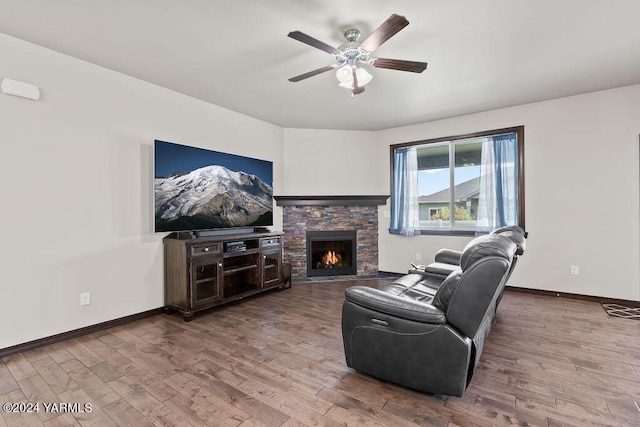 living room featuring a fireplace, wood finished floors, and baseboards