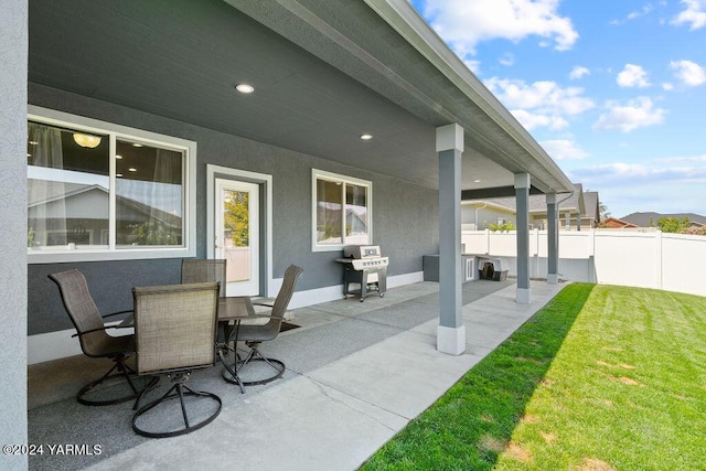 view of patio with outdoor dining space, a grill, and fence