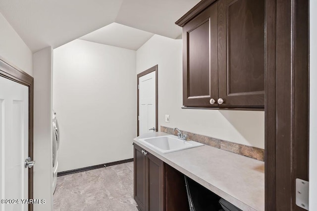 interior space with cabinet space, a sink, and baseboards