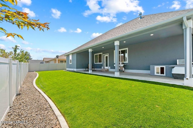 back of house featuring a yard, a fenced backyard, stucco siding, and a patio