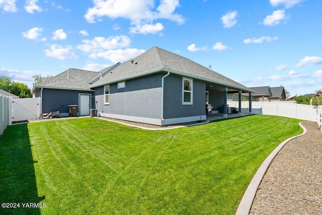 rear view of property featuring a patio, a fenced backyard, a yard, a gate, and stucco siding