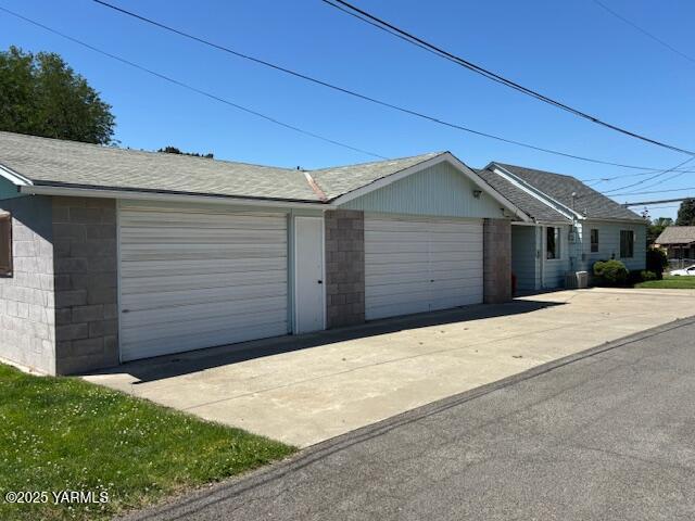 908 W 5th St, Grandview, WA 98930 - view of front facade featuring a garage, driveway, and a shingled roof
