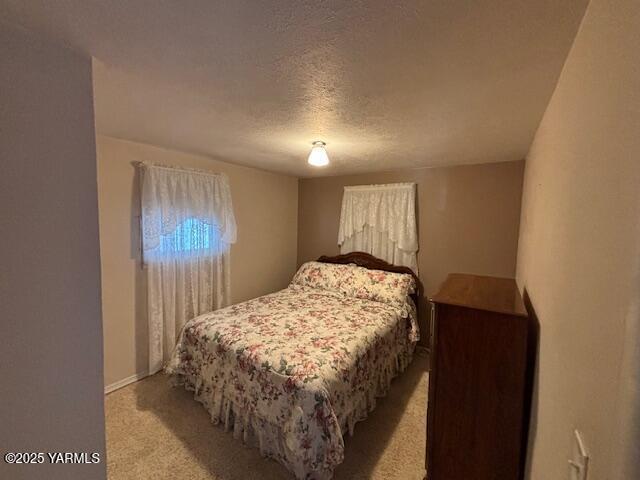 908 W 5th St, Grandview, WA 98930 - bedroom with light carpet and a textured ceiling