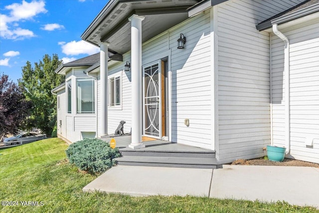 entrance to property featuring a lawn