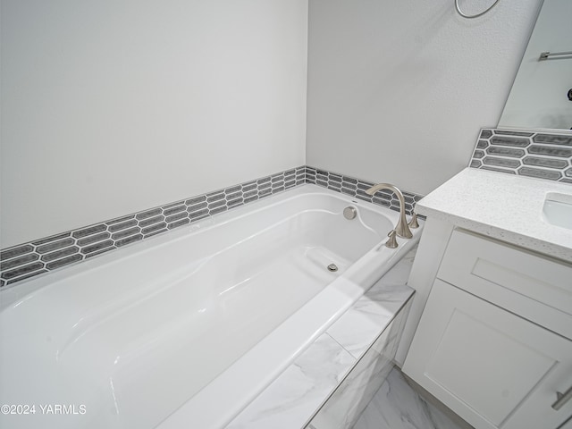 bathroom featuring a garden tub and vanity