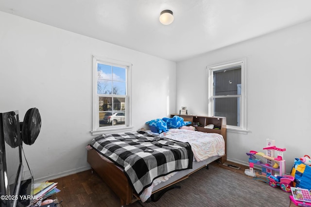 bedroom featuring dark wood-style floors, visible vents, and baseboards