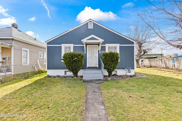 bungalow with fence and a front yard