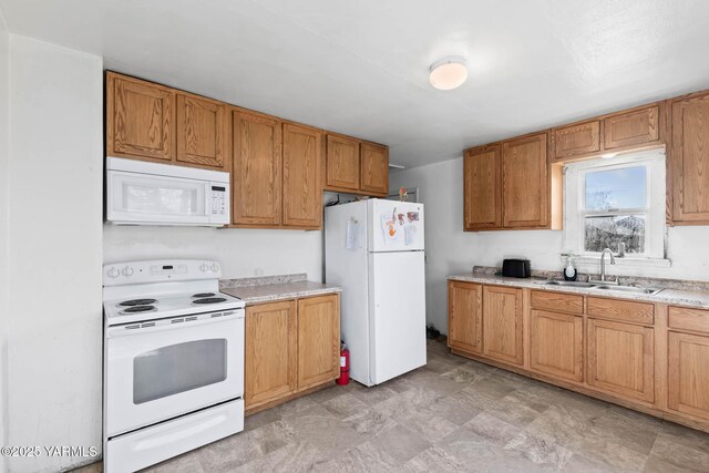 kitchen with light countertops, white appliances, a sink, and brown cabinets