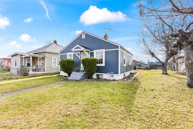 view of front of house featuring fence, a chimney, and a front lawn