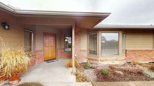 doorway to property with brick siding