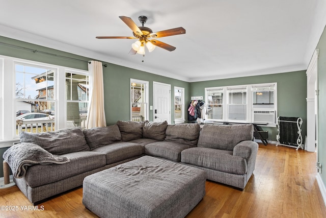 living room featuring ceiling fan, a fireplace, wood finished floors, and cooling unit