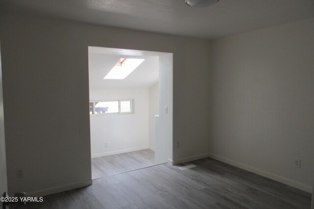 8108 Poplar View Way, Yakima, WA 98908 - spare room with a skylight, wood finished floors, and baseboards