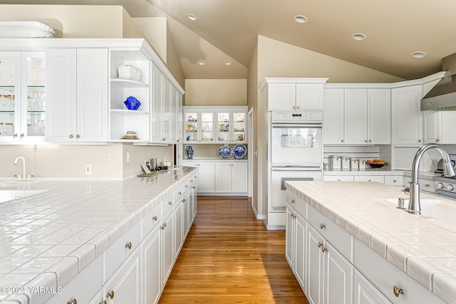 kitchen featuring glass insert cabinets, white cabinetry, and tile countertops