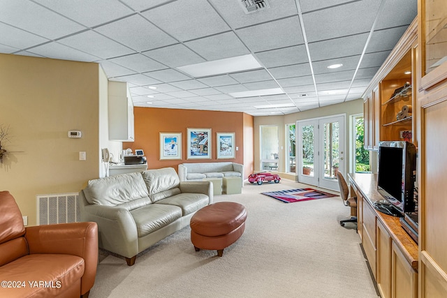 living area featuring french doors, a paneled ceiling, visible vents, and light colored carpet