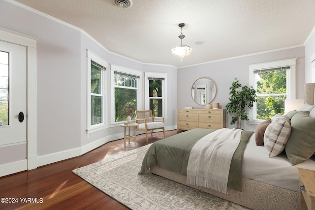 bedroom with ornamental molding, dark wood-style flooring, visible vents, and baseboards