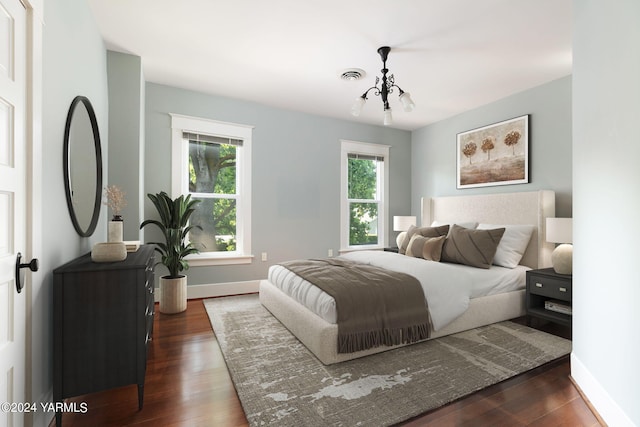 bedroom with a notable chandelier, baseboards, visible vents, and dark wood-style flooring