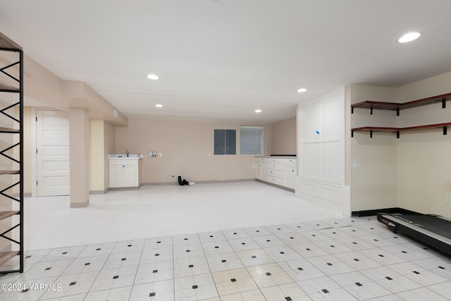 interior space featuring baseboards, light floors, a sink, and recessed lighting