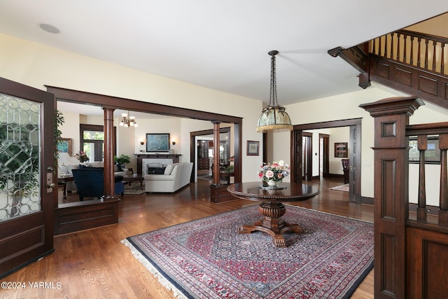 entryway with dark wood-style floors and decorative columns