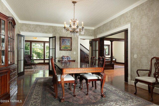 dining space with dark wood-style floors, ornamental molding, and wallpapered walls